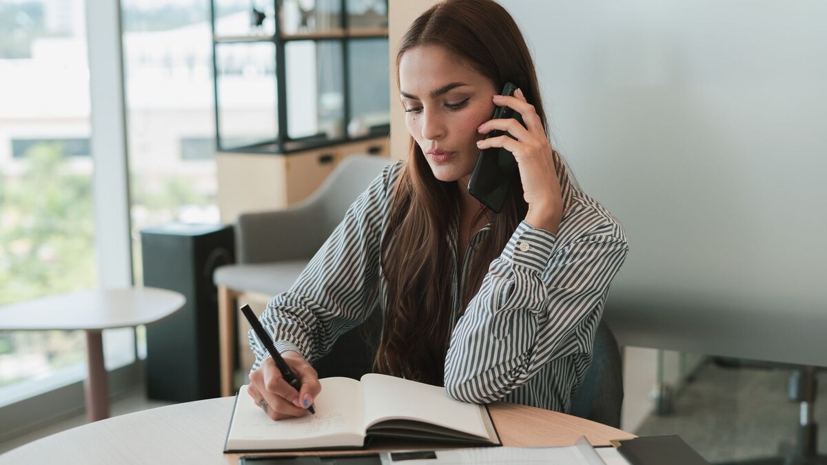 Small-business operator taking notes during a phone call